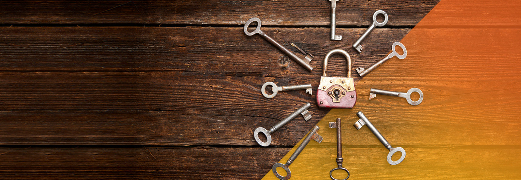 A padlock is surrounded by nine antique keys arranged in a circular pattern on a wooden surface with a warm brown and orange gradient background.