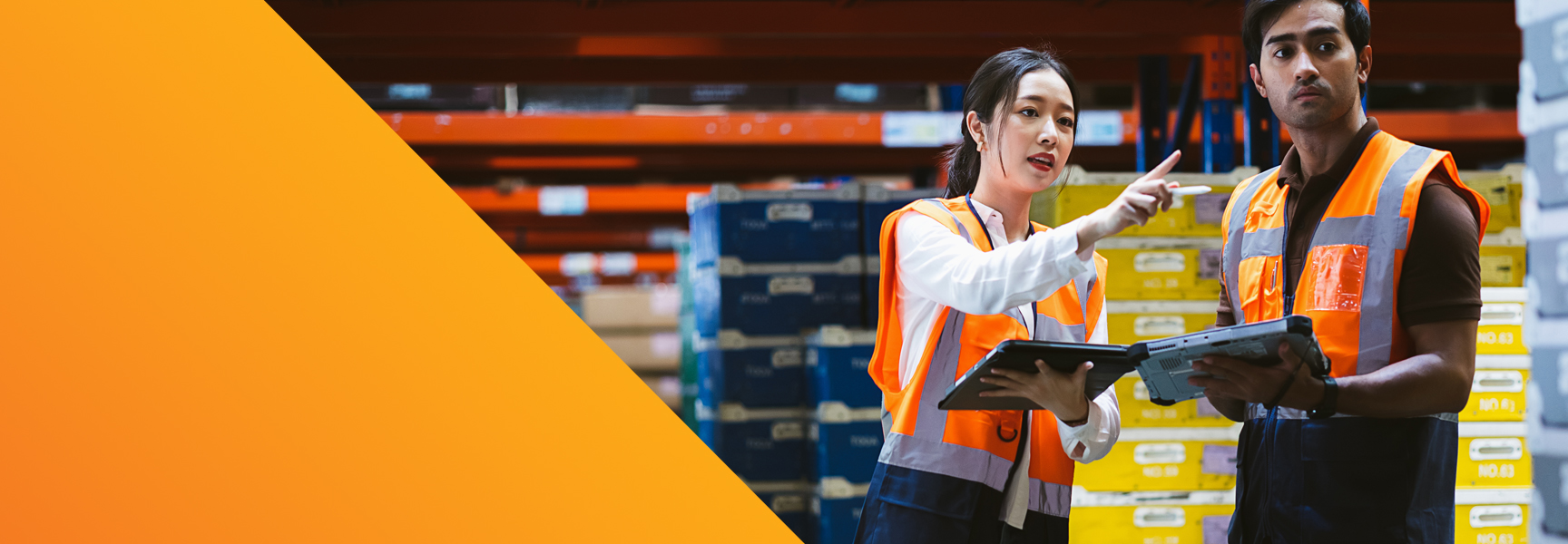 Two warehouse workers in orange safety vests stand among shelves of boxes, one holding a tablet and the other a clipboard, suggesting a discussion or planning activity focused on managing channel partner relationships.